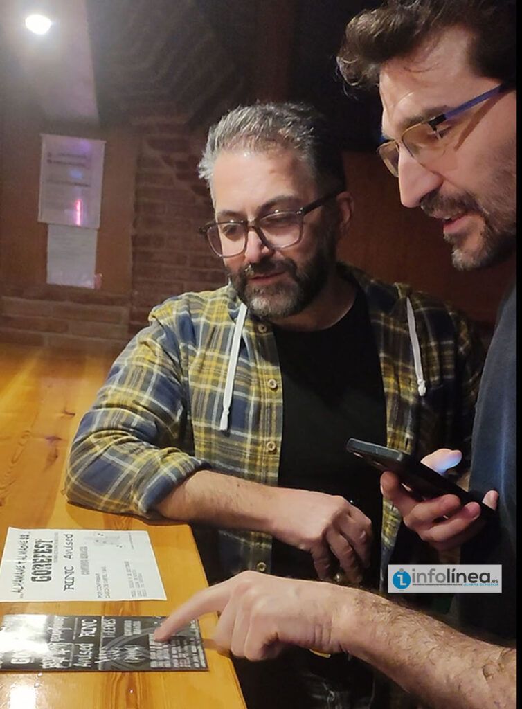 El entrevistado, con Desi, entrevistador, viendo carteles del festival alhameño con el que empezó su andadura como promotor